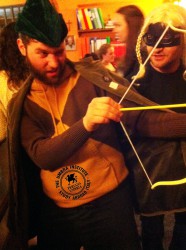 Robin Hood, formally known as Umbra staff member Marco Bagli, draws an arrow at the Carnevale-themed Pizza Night Tuesday night as Giuliano Agamennoni as a blonde, masked figure looks on.
